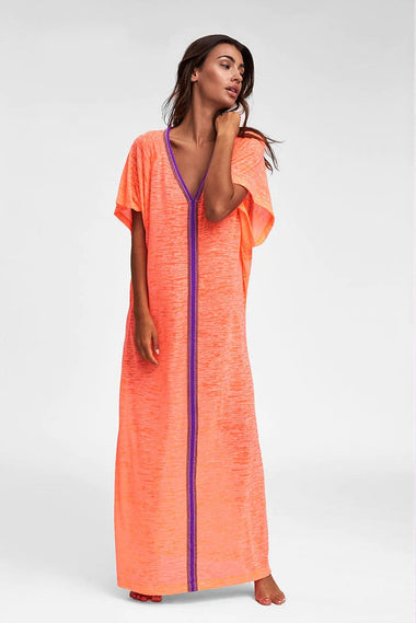 Woman showcasing floor-length orange beach cover up