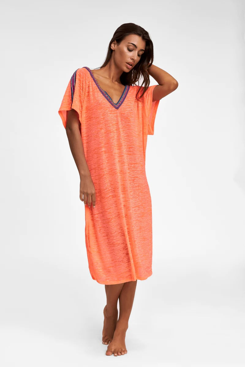 Woman donning the V Back Dress Coral - A loose fitting summer dress