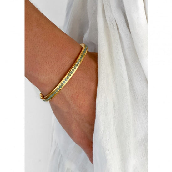 Woman wearinginlay stone gold bracelet by Sara Lashay