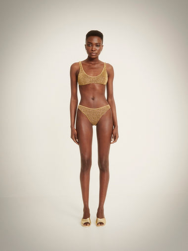 woman wearing a gold bikini set by oseree swimwear